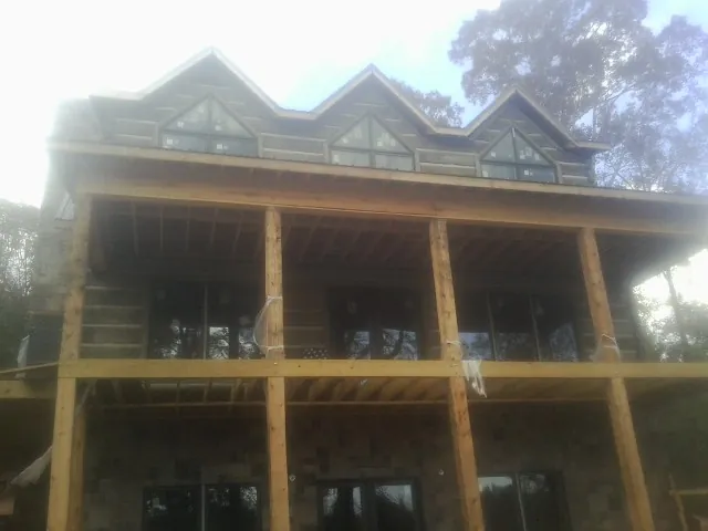 Dormers and porch framing on a large log home under construction in Mc Cutchenville