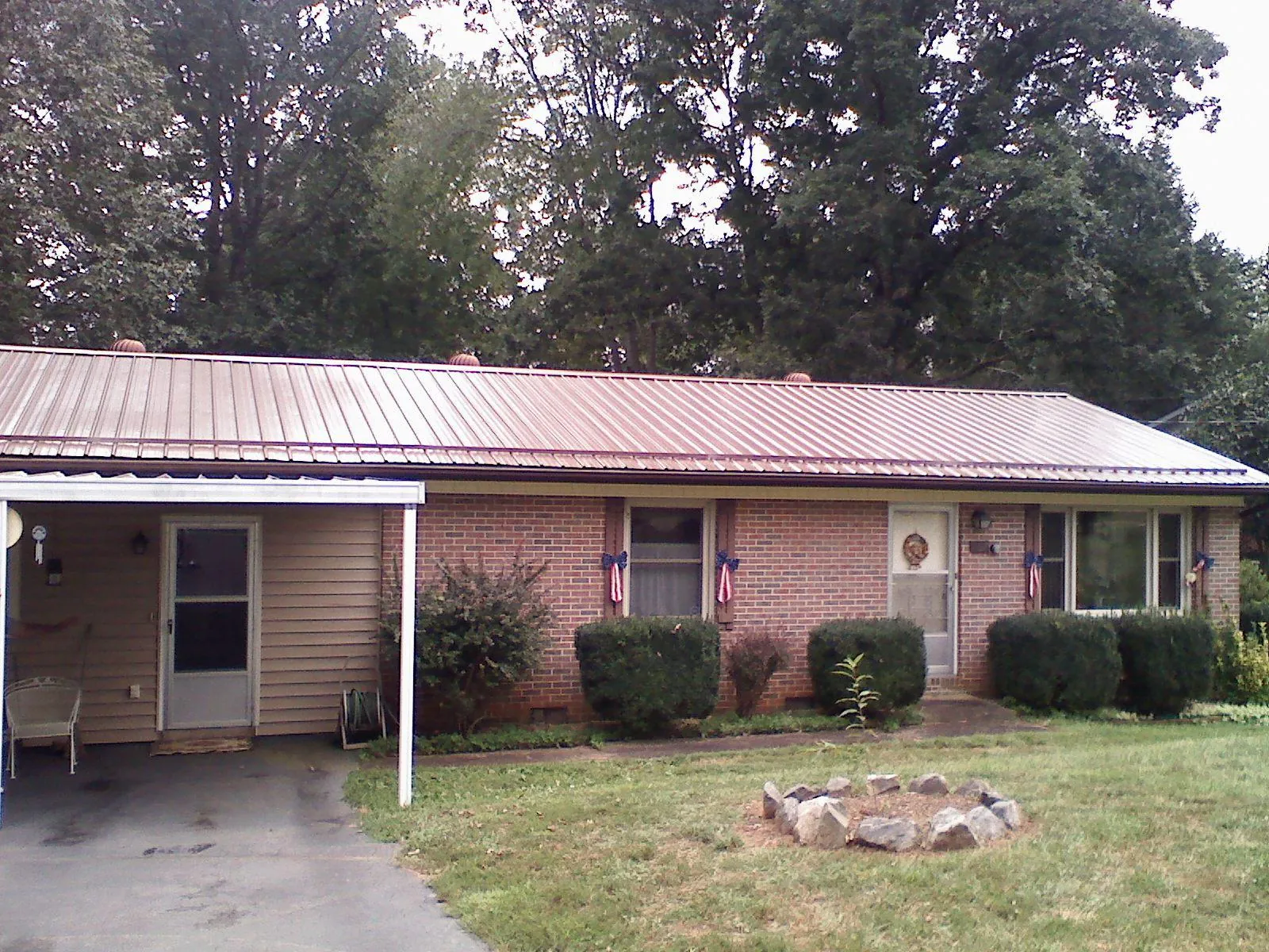 Bronze metal roof and carport on a brick ranch home — Roof Repair work by our crew in Mc Cutchenville